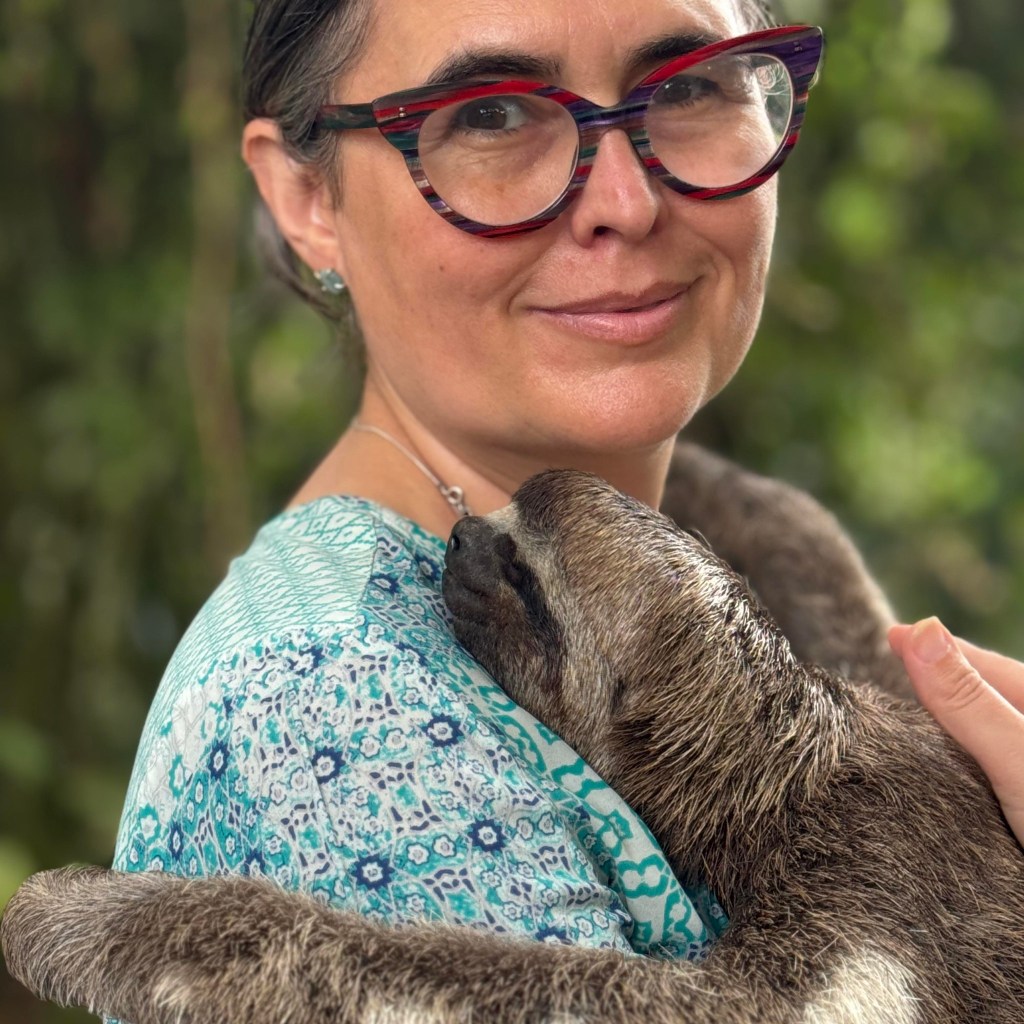 Author Sara Fajardo cuddling a sloth.